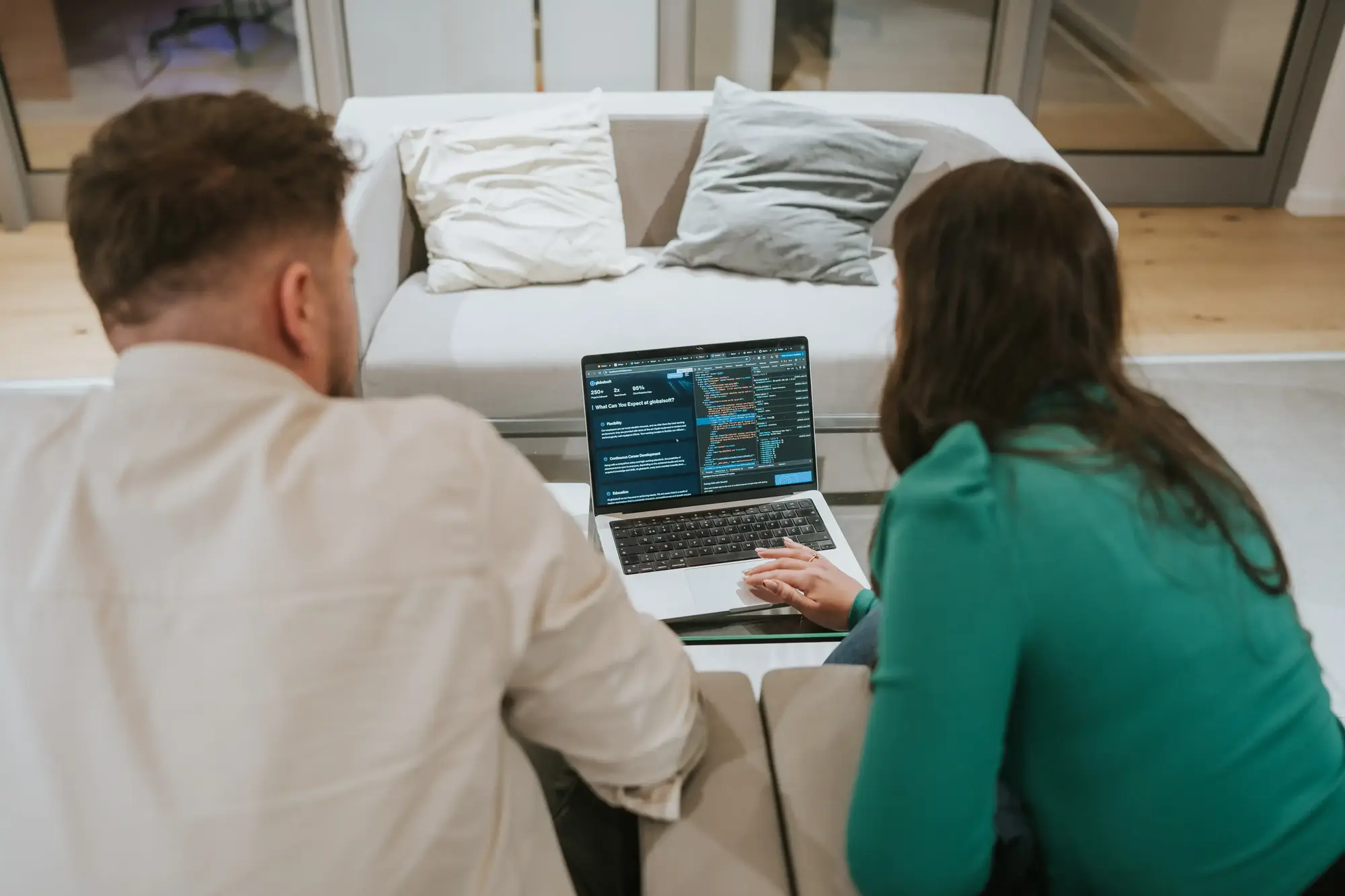 Two globalsoft employees working on a laptop